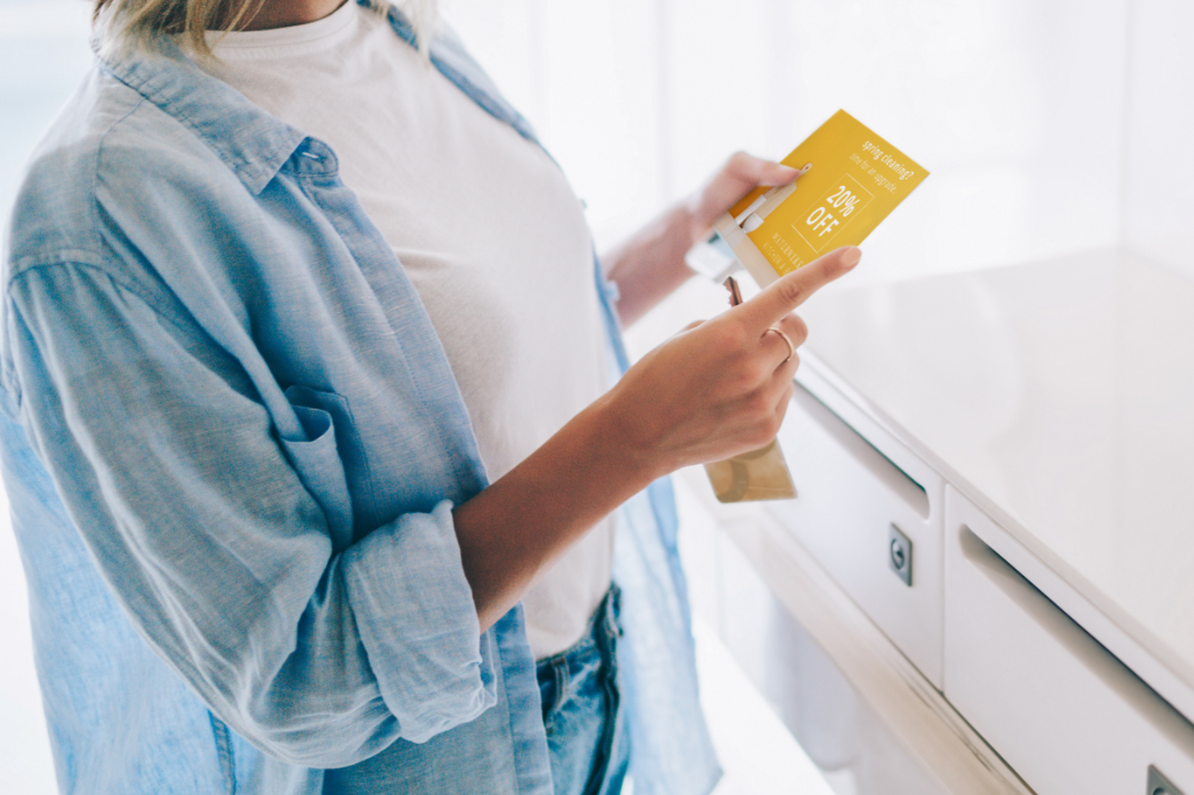 Woman holding a direct mail postcard