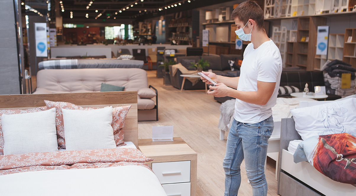 man viewing a bed sample in a warehouse