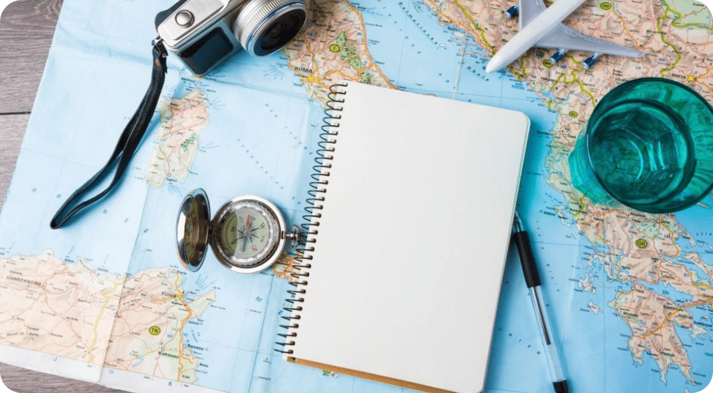 Image of map covered in travel notebook and camera