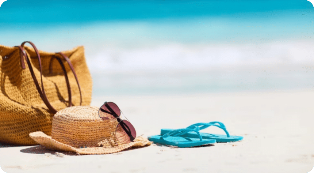 Sandy beach with sunhat, bag, and flipflops