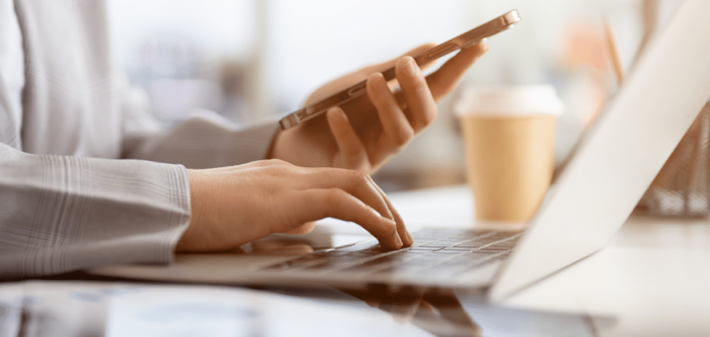 Person contacting company via cell and laptop